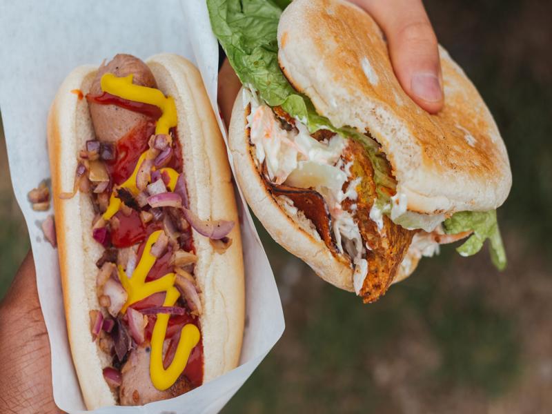 VEGAN HOT DOG WITH FRIED ONIONS, MUSTARD AND VEGAN CHIKUN BURGER WITH WORKS.