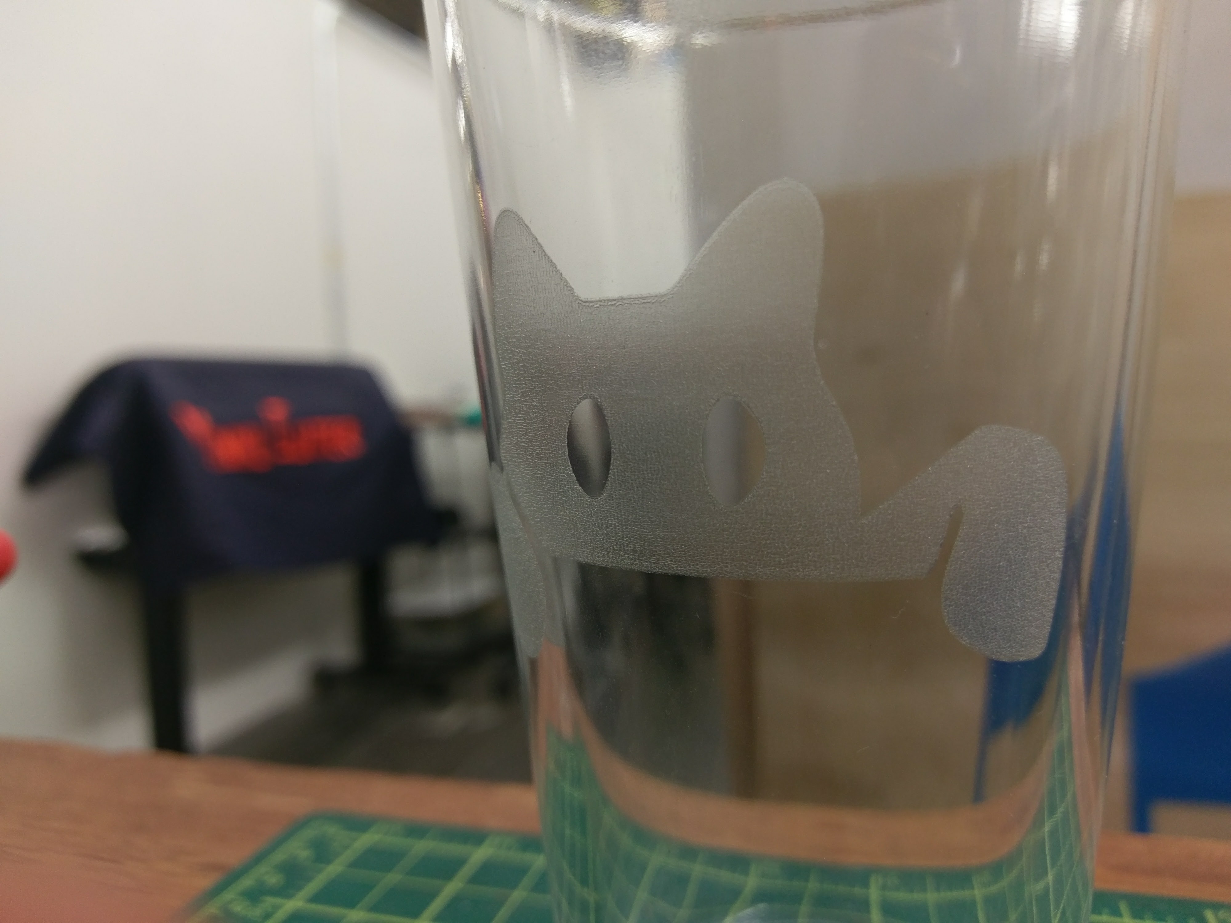 Photo of pint glass engraved with black cat logo