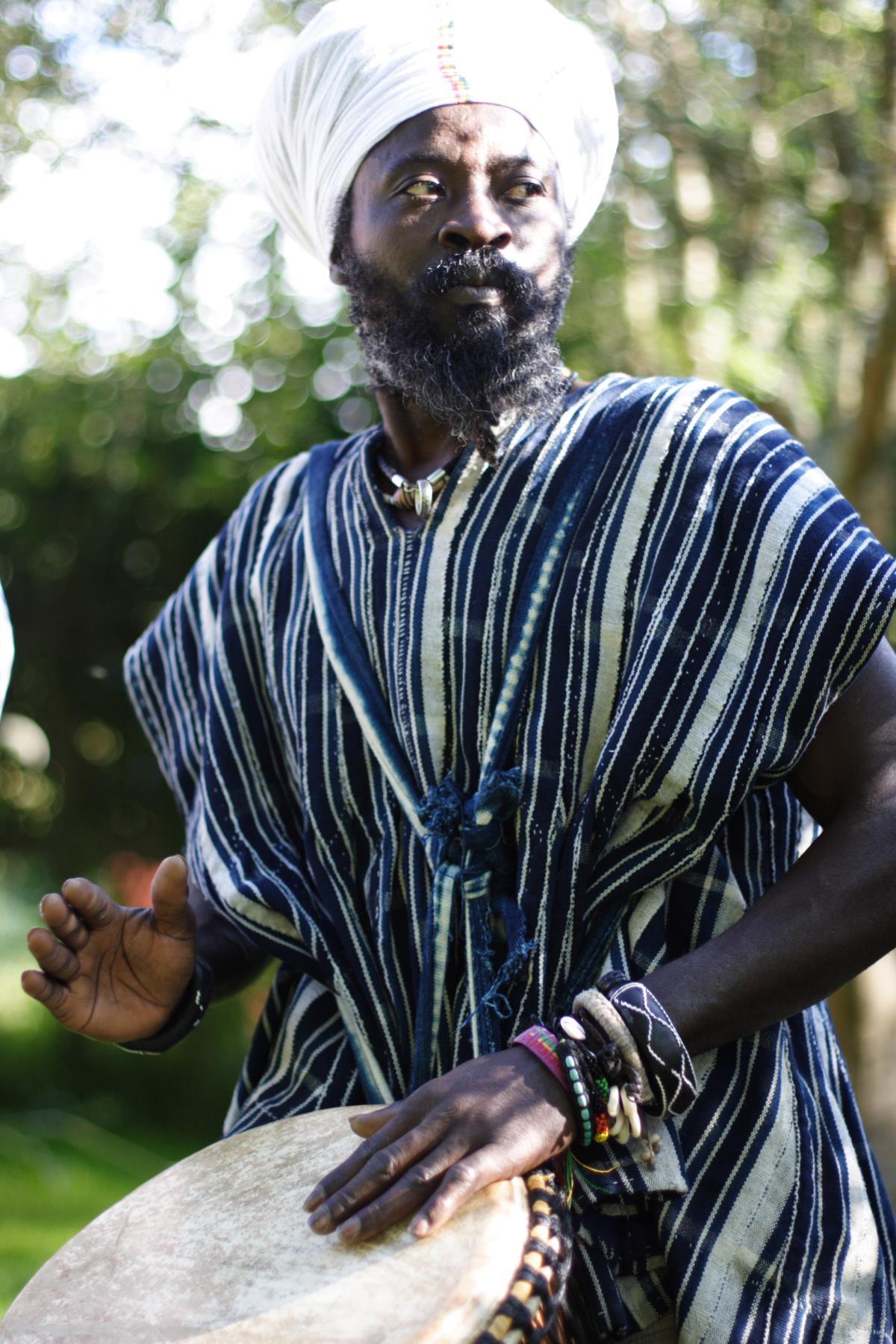 Kwame holding his djembe and looking thoughtful!