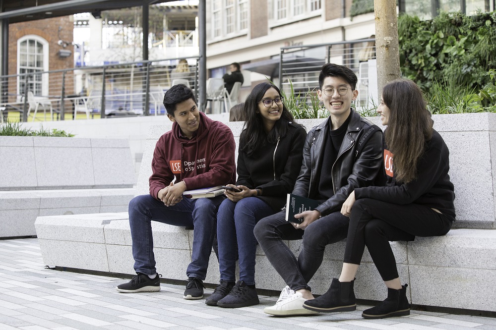 Four students sitting outside, chatting
