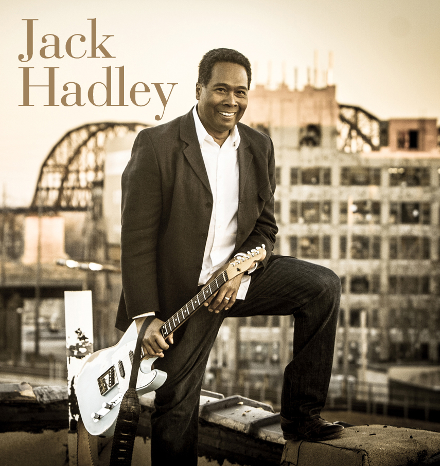 image of musician Jack Hadley smiling and holding a guitar