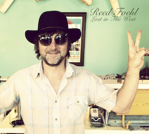 reed foehl wearing a floppy hat and some sunglasses while he flashes a peace sign. this is the cover of his new CD "Lost In The West"