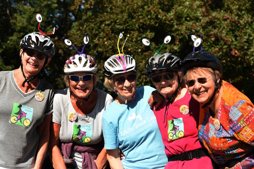 Five women with fun bike helmet decorations pose for a photo during the Saint Paul Classic Bike Tour.
